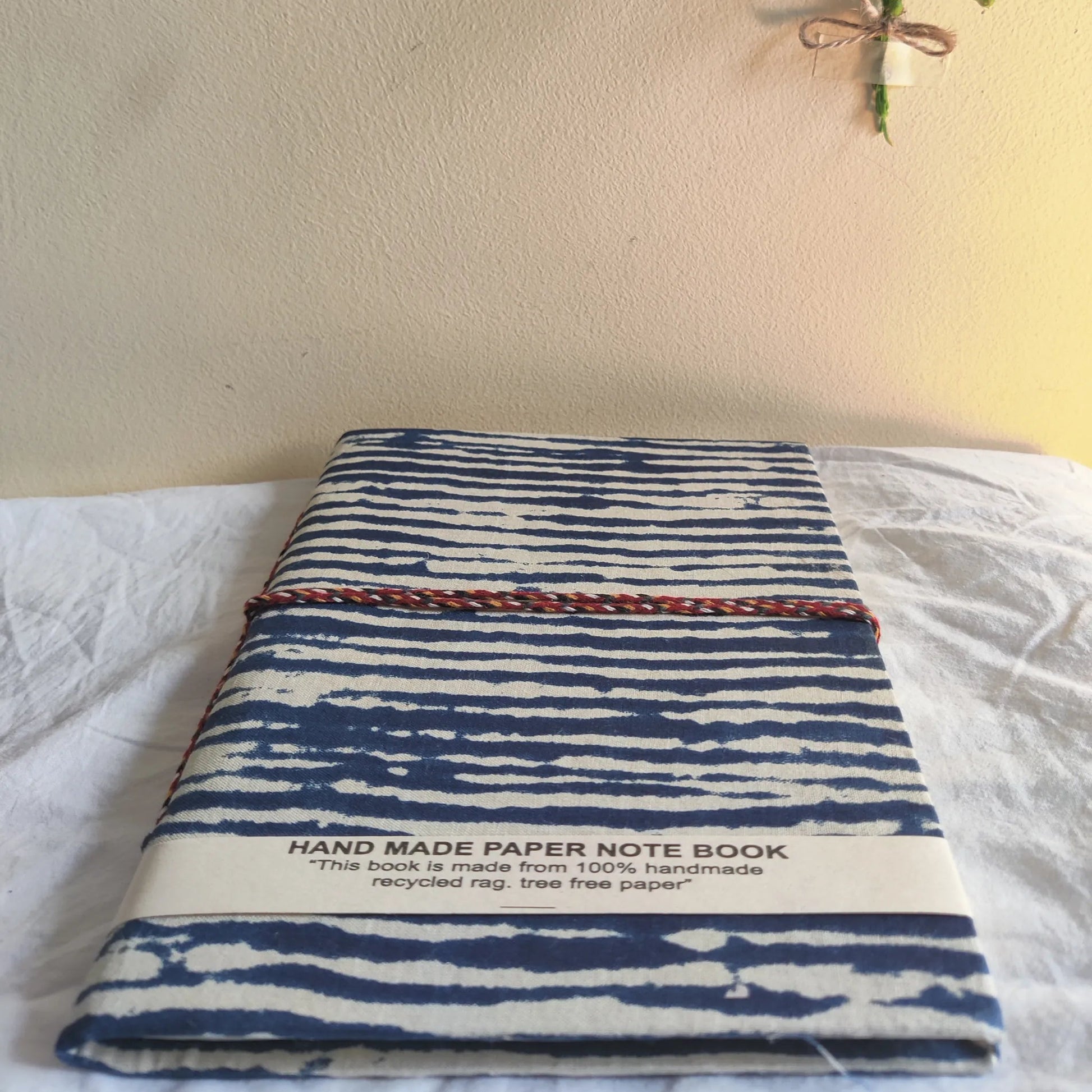 Handmade paper rope journal in ocean waves - flatlay view