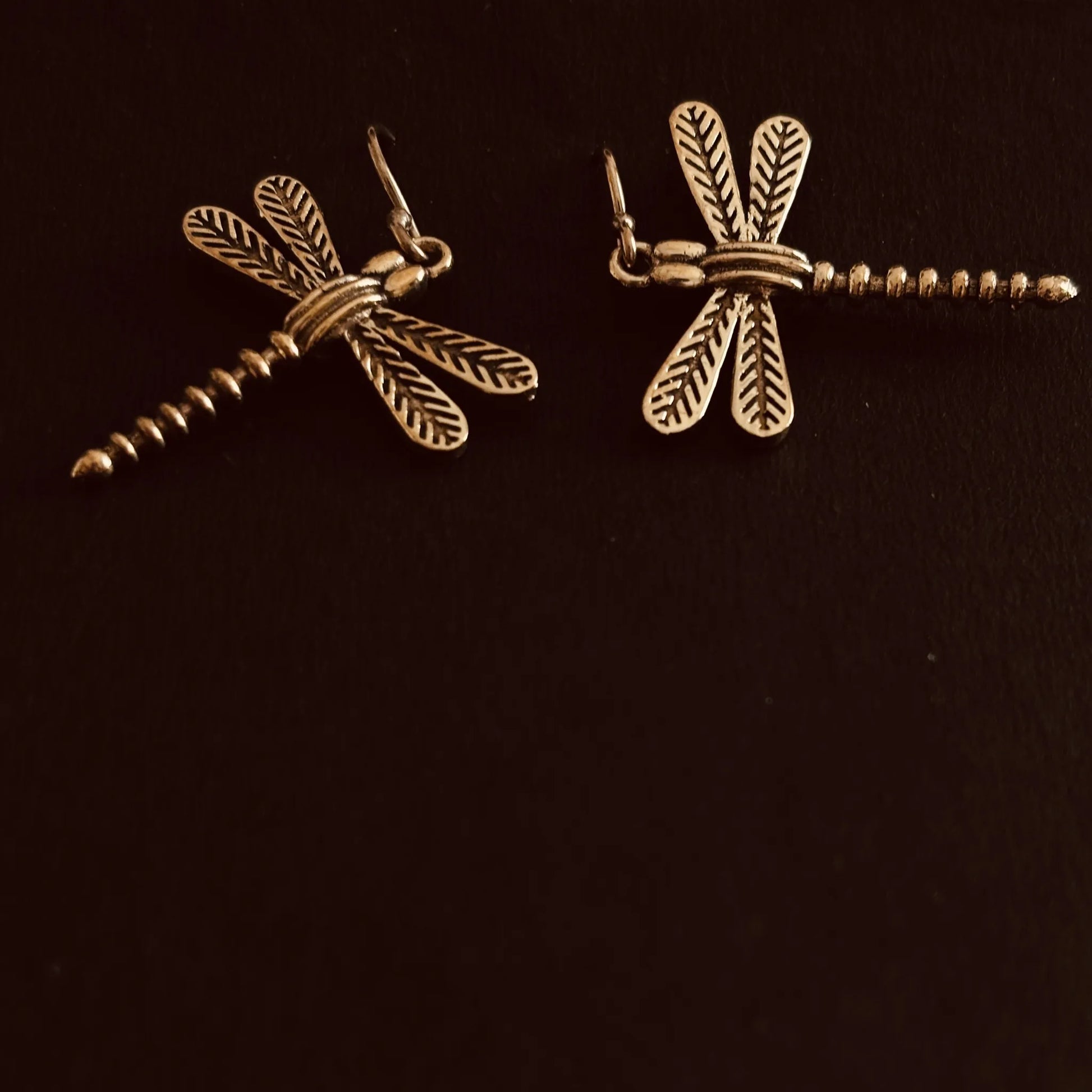 Reverse view of dragonfly brass earrings showing wing and tail texture