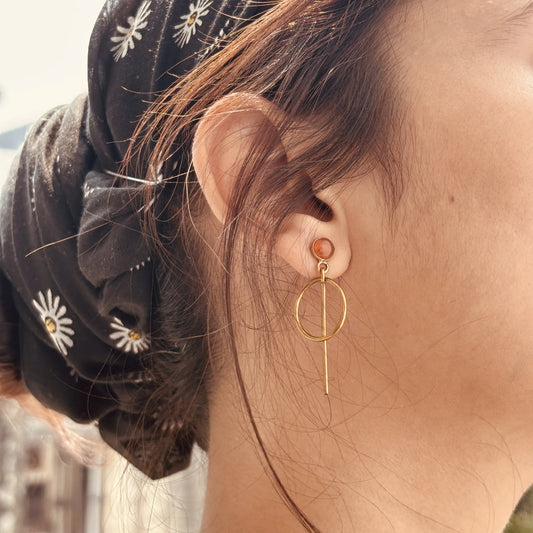 Side view of carnelian orbit drops earrings on model